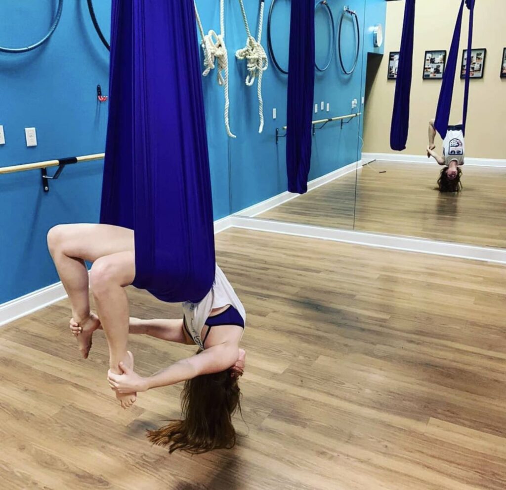 aerial hammock or aerial yoga back bend in front of mirror