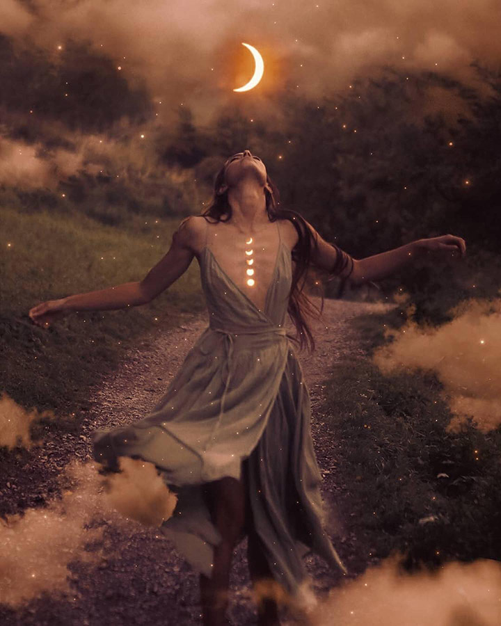 girl in a flowing dress outside looking up with moon phases on her chest surrounded by clouds and stars