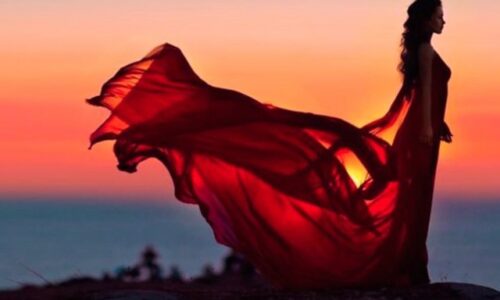 woman standing in the sunset with a flowing veil